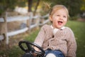 Young Toddler Laughing and Playing on Toy Tractor Outside Royalty Free Stock Photo