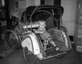 A young toddler sitting in an old fashion car