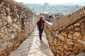 A young tourist with a backpack shoots video on smartphone, standing on a Fortress wall