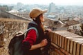 A young tourist with a backpack shoots video on smartphone, standing on a Fortress wall