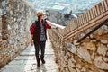 A young tourist with a backpack shoots video on smartphone, standing on a Fortress wall