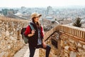 A young tourist with a backpack shoots video on smartphone, standing on a Fortress wall