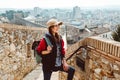 A young tourist with a backpack shoots video on smartphone, standing on a Fortress wall