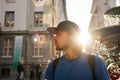 Young tourist in baseball hat with old city background