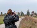 Young tourist in black leather jacket photographs the Crimean landscape