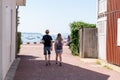 Young tourist couple in oyster village Le Canon in Cap Ferret France in back view