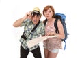 Young tourist couple reading city map looking lost and confused loosing orientation with girl carrying travel backpack Royalty Free Stock Photo