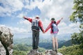 Young tourist couple watching spectacular mountain scenery in high mountains. man and woman hiker on top rock. A couple of Royalty Free Stock Photo