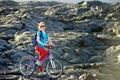 Young tourist cycling on lava field on Hawaii. Female hiker heading to lava viewing area at Kalapana town on her bike.