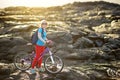 Young tourist cycling on lava field on Hawaii. Female hiker heading to lava viewing area at Kalapana on her bike. Tourist on hike Royalty Free Stock Photo