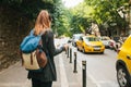 A young tourist girl with a backpack in a big city is watching a map. Journey. Sightseeing. Travel. Royalty Free Stock Photo