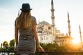A young tourist girl with a beautiful figure looks from the hotel terrace to the world famous blue mosque Sultanahmet in Royalty Free Stock Photo