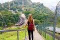 Young tourist girl carrying backpack descending stairs and enjoying the view from Jaragua Peak, Brazil