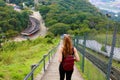 Young tourist girl carrying backpack descending stairs and enjoying the view from Jaragua Peak, Brazil