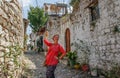 A young tourist girl in a pink blouse is standing on a cobbled road in the ancient Albanian town of Berat, overlooking the medieva