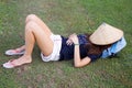 Young tourist lady lying on green grass sleeping