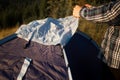 Young tourist man setting up tent on autumn meadow, traveling high in mountains