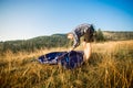 Young tourist man setting up tent on autumn meadow, traveling high in mountains