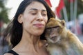 Young tourist petting a monkey in Jemaa el Fna square in Marrakech in Morocco Royalty Free Stock Photo