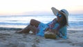 Young tourist pretty woman in sunglasses and the hat lying on tropical paradise sandy beach and drinks coconut juice Royalty Free Stock Photo