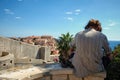 Tourist resting sitting on a wall in front Dubrovnik Old Town