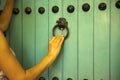 Young tourist\'s hand knocking on the handle of a big blue door to enter the Majorelle botanical garden in Marrakech, Morocco