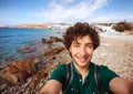 Young tourist taking selfie on Mykonos beach, Greece.