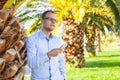 Young tourist under palm tree with mobile phone and tablet. Nega Royalty Free Stock Photo