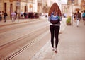 Young tourist woman with backpack walk by street in old europe city, summer fashion style Royalty Free Stock Photo