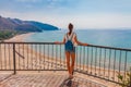 Young tourist woman on the beach and sea landscape with Sperlonga, Lazio, Italy. Scenic resort town village with nice sand beach