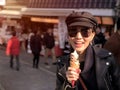 Young tourist woman eating ice cream cone covered with real gold leaf a famous street food in Japan Royalty Free Stock Photo