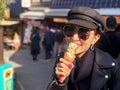 Young tourist woman eating ice cream cone covered with real gold leaf a famous street food in Japan Royalty Free Stock Photo