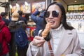 Young tourist woman eating yakitori, chicken grilled as the famous street food at bamboo forest Arashiyama in Japan Royalty Free Stock Photo