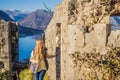 Young tourist woman enjoying a view of Kotor Bay, Montenegro. Kotor Old Town Ladder of Kotor Fortress Hiking Trail Royalty Free Stock Photo