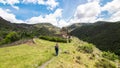 A young tourist woman during the hike in the Pyrenees mountains. On her way to the ancient church of Sant Serni de Nagol