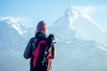 A young tourist woman with a hiking backpack and a knitted hat in the Himalaya mountains. trekking concept in the Royalty Free Stock Photo