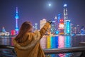 Young tourist woman pointing a finger at the bund in shanghai, china.