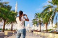 Young tourist woman shooting on mobile phone Sheikh Zayed great white mosque in Abu Dhabi, United Arab Emirates, Persian gulf. UAE Royalty Free Stock Photo