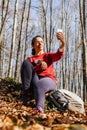 Young tourist woman take a picture in the autumn forest Royalty Free Stock Photo