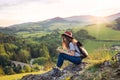 Young tourist woman traveller with backpack sitting in nature, writing notes. Royalty Free Stock Photo