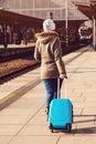Young tourist woman walking, dragging luggage suitcase bag. Girl at railway station. Journey concept. Lifestyle, travelling, vacat Royalty Free Stock Photo