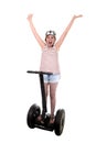 Young tourist woman wearing safety helmet rising arms up hands free smiling happy riding electrical segway