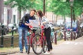 Young tourists couple looking at map in european city.