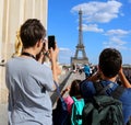 Young tourists take pictures of Eiffel Tower in Paris France