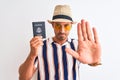 Young tourtist man wearing summer hat and holding USA passport over isolated background with open hand doing stop sign with Royalty Free Stock Photo