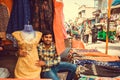 Young trader working with female fashion in textile store of busy market street