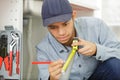 young tradesman measuring pvc pipe