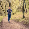 Young trail runner man jogging in the morning park