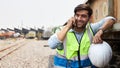 A young train engineer standing on the phone