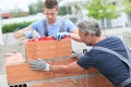 Young trainee learning masonry with instructor